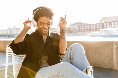Sevimli Afro-Amerikan kadın dans portre closeup ve nehir kenarında yakın kulaklık ile müzik dinlerken
