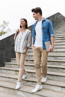 Açık havada merdivenlerden aşağı yürürken gülümseyen ve konuşan tür çift Görüntü