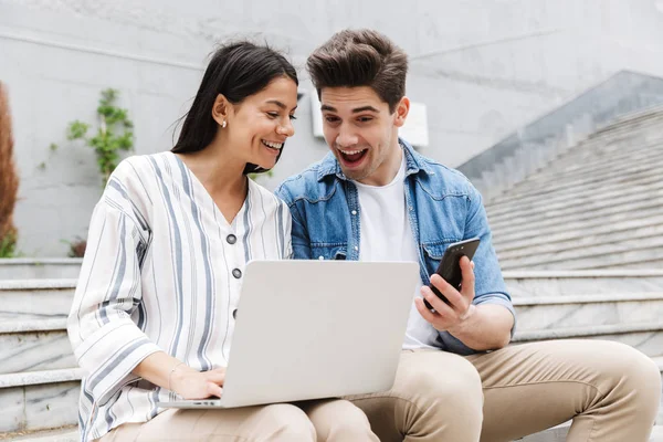 Increíble pareja amorosa gente de negocios colegas al aire libre utilizando el teléfono móvil y ordenador portátil . —  Fotos de Stock