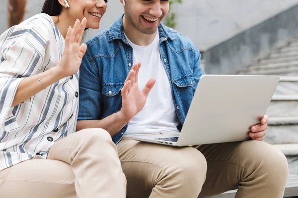 Szczęśliwy młody niesamowite kochający para biznes ludzie koledzy zewnątrz zewnątrz u kroki przy pomocy laptop rachmistrz machając rozmowa rezygnować rodzina albo przyjaciele. — Zdjęcie stockowe