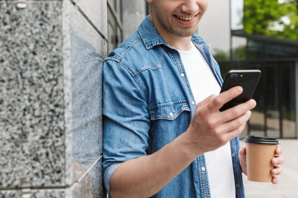 Boldog fiatal csodálatos férfi üzletember pózol a szabadban kívül gyaloglás beszélgető mellett mozgatható telefon ivás kávé. — Stock Fotó