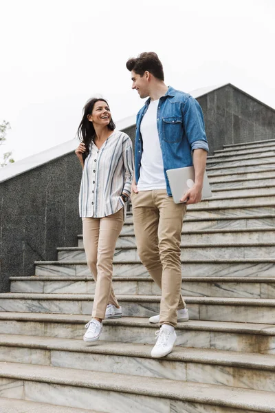 Immagine di una coppia felice che sorride e parla passeggiando per le scale all'aperto — Foto Stock
