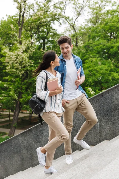 Increíble pareja amorosa estudiantes al aire libre caminando por los pasos con libros . — Foto de Stock