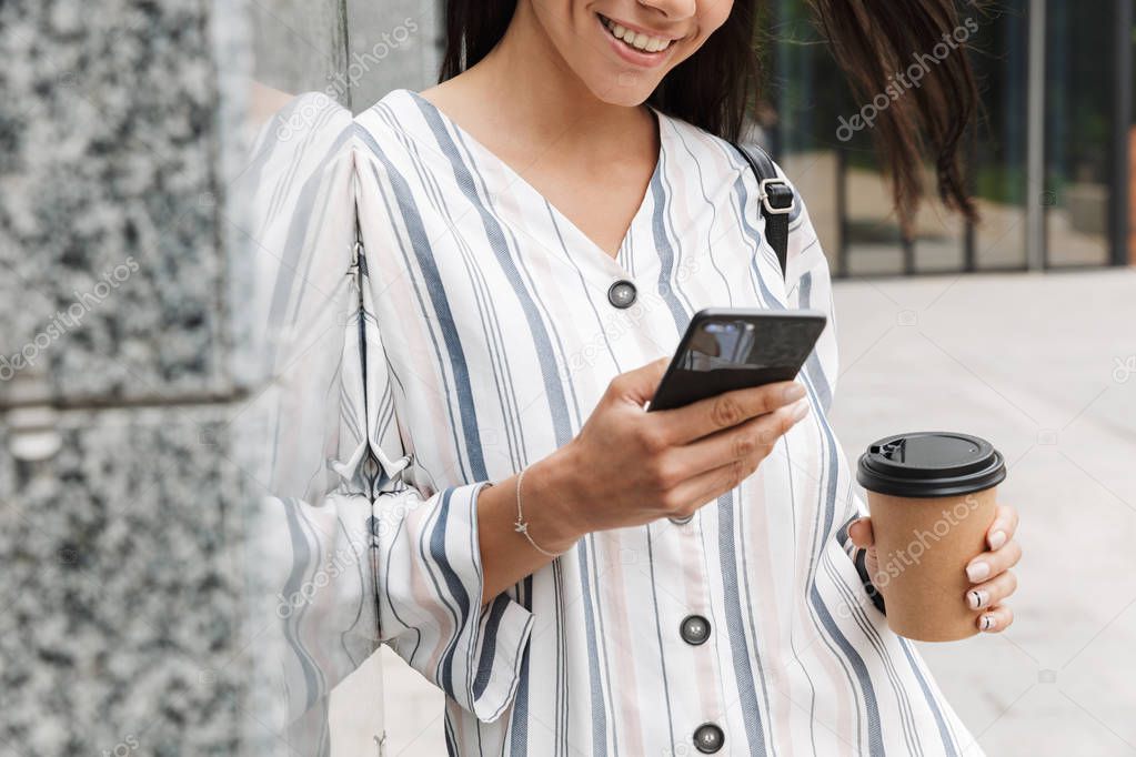 Happy young beautiful woman businessman posing outdoors outside walking chatting by mobile phone drinking coffee.