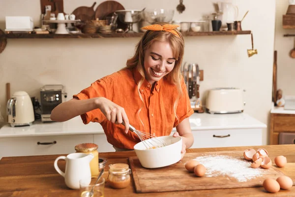 Mutlu neşeli gülümseyen genç sarışın kız şef mutfakta yemek. — Stok fotoğraf