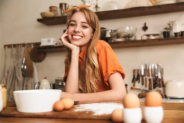 Mutlu neşeli gülümseyen genç sarışın kız şef mutfakta yemek. — Stok fotoğraf