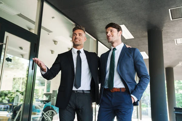 Retrato de dos socios de negocios satisfechos conversando juntos —  Fotos de Stock