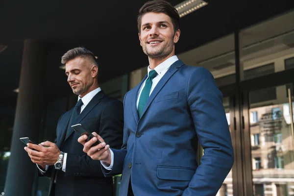 Image de joyeux hommes d'affaires partenaires debout à l'extérieur du bureau cen — Photo