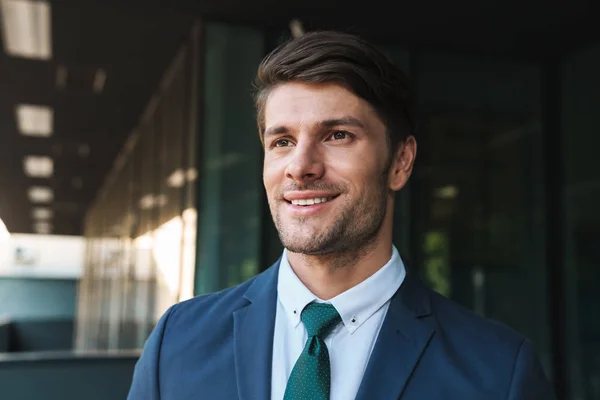 Photo of happy businessman dressed in formal suit smiling and st — Stock Photo, Image