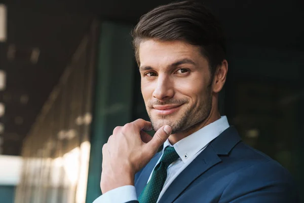 Foto de primer plano de atractivo hombre de negocios tocándose la barbilla mientras —  Fotos de Stock