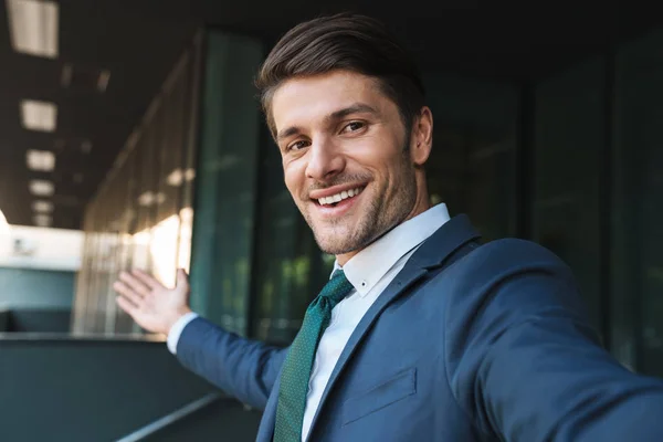Foto de un hermoso hombre de negocios sonriendo a la cámara y tomando uno mismo — Foto de Stock