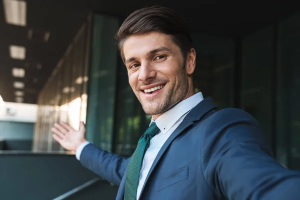 Photo d'un bel homme d'affaires souriant à la caméra et se prenant soi-même — Photo