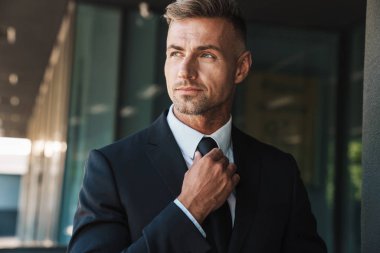 Olgun yakışıklı gri saçlı iş adamı iş merkezi yakınındaki sokakta açık havada.