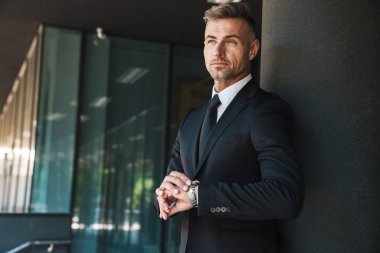 Olgun yakışıklı gri saçlı iş adamı iş merkezi yakınındaki sokakta açık havada.