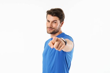 Çekici genç fit sporcu ayakta t-shirt giyiyor