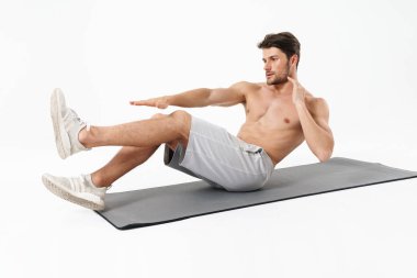 Photo of young shirtless man lying on fitness mat and doing cris clipart