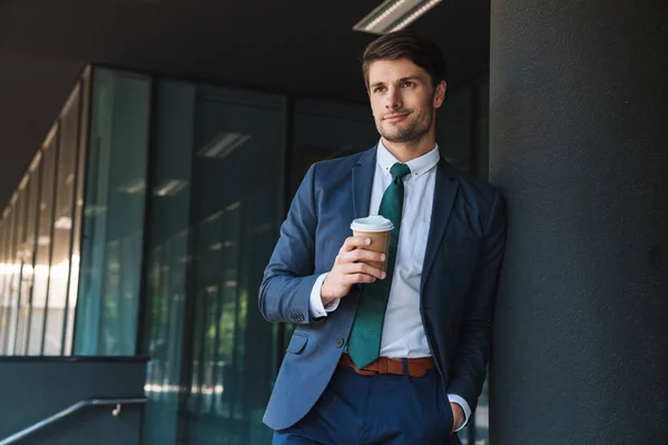 Photo of young businessman drinking takeaway coffee from paper c — Stock Photo, Image