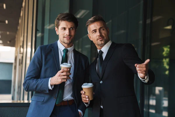 Image of caucasian businessmen partners talking and drinking tak — Stock Photo, Image