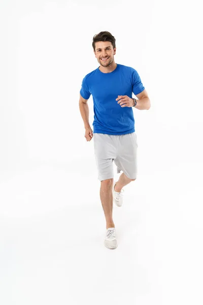 반바지와 티셔츠를 입고 웃는 즐거운 운동 남자의 사진 — 스톡 사진