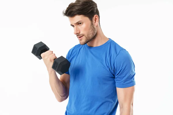 Serious handsome young sports fitness man standing isolated over white wall background holding dumbbells. — Stock Photo, Image