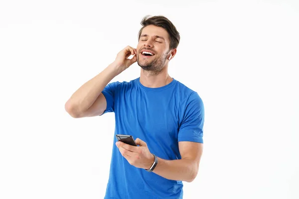 Fotografie veselého muže, zpívající v příležitostné košili, zpěv a telefon Smartphone při nošení bezdrátových sluchátek — Stock fotografie