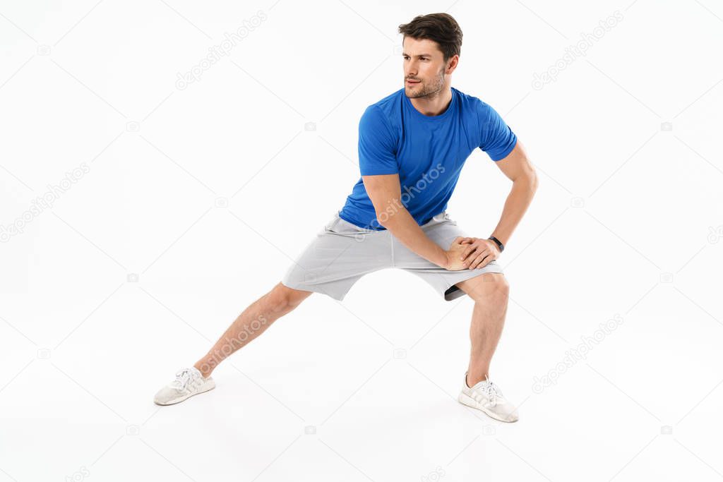 Photo of young athletic man in shorts and t-shirt doing sporty e