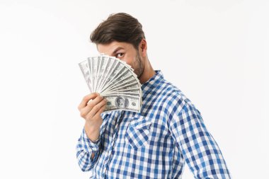 Sakallı tıraşsız adam rahat gömlek giymiş beyaz duvar arka plan üzerinde yüz kapsayan para tutarak izole poz.