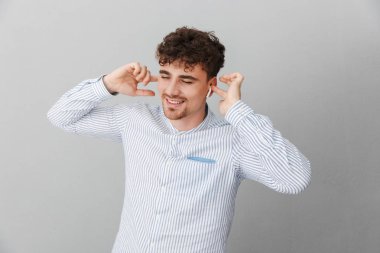 Joyful genç adam gülümseyen ve earpods ile müzik dinlerken Görüntü