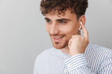 Earpods gülümseyen ve kenara bakarak yakışıklı genç adamın Görüntü closeup