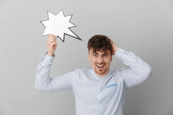 Portrait of astonished beautiful man dressed in shirt holding bl