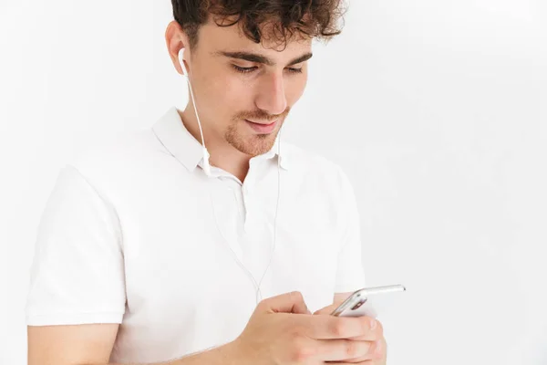 Foto de primer plano de hombre rizado joven en camiseta casual usando el auricular — Foto de Stock