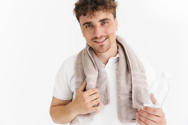 Foto de primer plano de hombre positivo con toalla sonriendo a la cámara y h — Foto de Stock