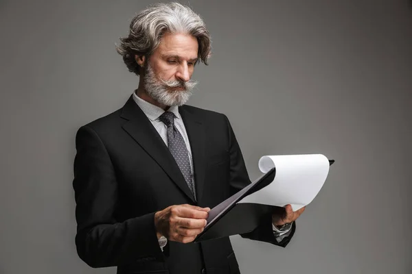 Image of caucasian adult businessman wearing formal black suit holding paper charts — Stock Photo, Image