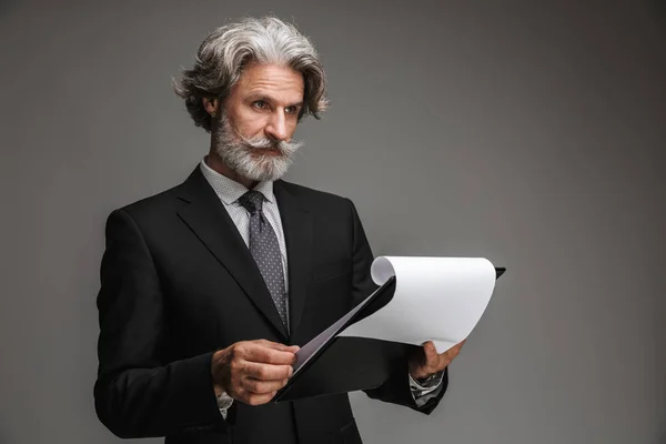 Image of confident adult businessman wearing formal black suit holding paper charts — Stock Photo, Image