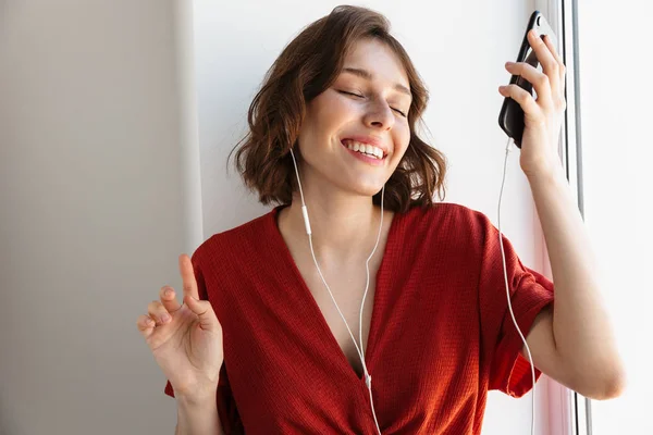 Porträtt av vacker brunett kvinna lyssnar på musik med SMA — Stockfoto