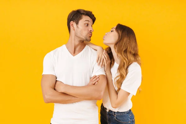 Porträt des romantischen Paares Mann und Frau in einfachen T-Shirts küssen — Stockfoto