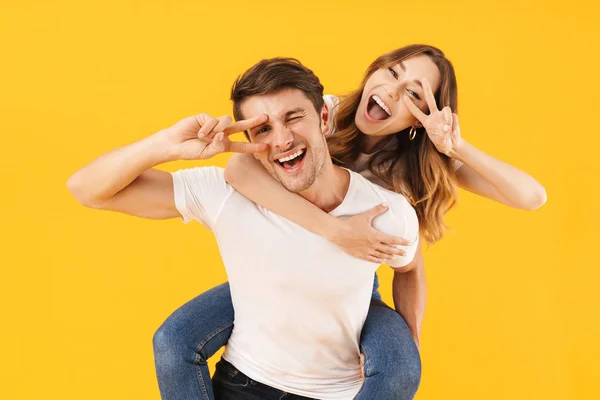 Retrato de pareja feliz hombre y mujer en camisetas básicas mostrando — Foto de Stock