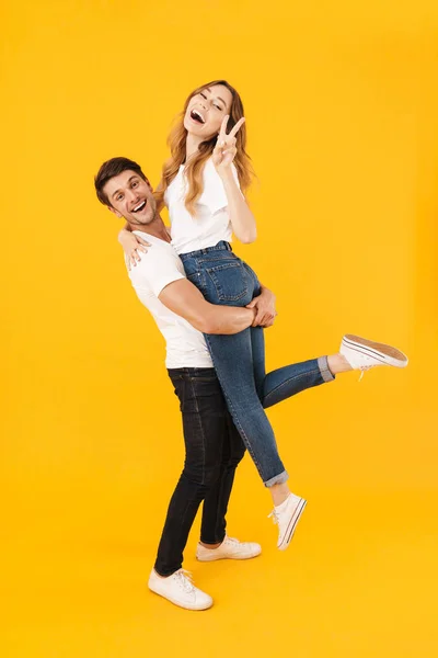 Retrato de comprimento total de casal animado em estandes de camisetas básicas — Fotografia de Stock