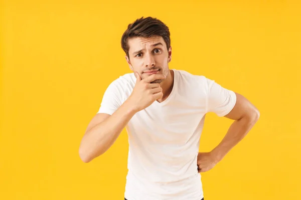 Foto van doordachte man in Basic t-shirt raken van zijn kin en l — Stockfoto