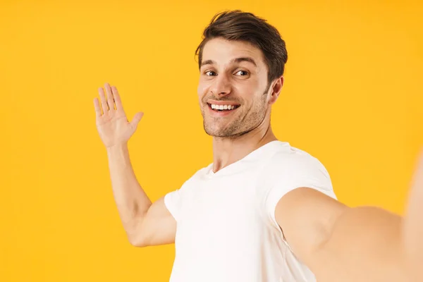 Foto van Happy man in Basic t-shirt glimlachend op de camera en de gestur — Stockfoto