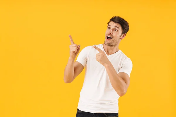 Foto de hombre sorprendido en camiseta básica preguntándose y haciendo gestos — Foto de Stock