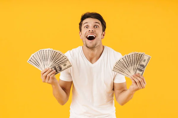 Foto eines erstaunten Mannes im einfachen T-Shirt, der sich freut, während er Brötchen hält — Stockfoto