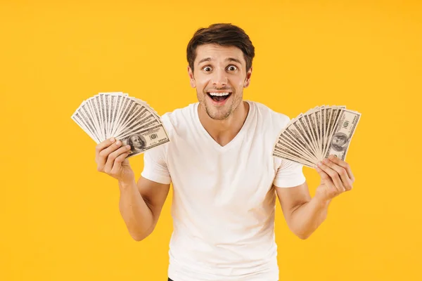 Photo of optimistic man in basic t-shirt rejoicing while holding — Stock Photo, Image