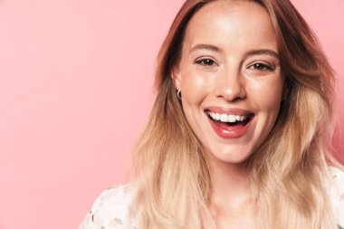 Güzel gülümseyen sarışın kadın pembe duvar arka plan üzerinde izole poz.