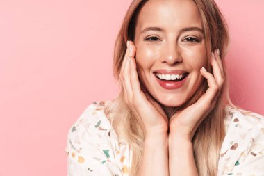 Güzel gülümseyen sarışın kadın pembe duvar arka plan üzerinde izole poz.