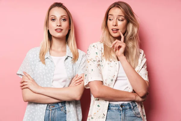 Sério bonita loiras mulheres posando isolado sobre rosa parede fundo . — Fotografia de Stock