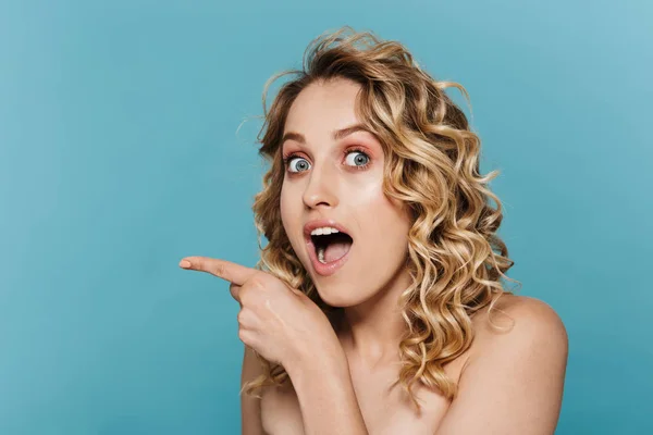 Imagem de beleza da jovem mulher semi-nua expressando surpresa e apontando o dedo para o copyspace — Fotografia de Stock