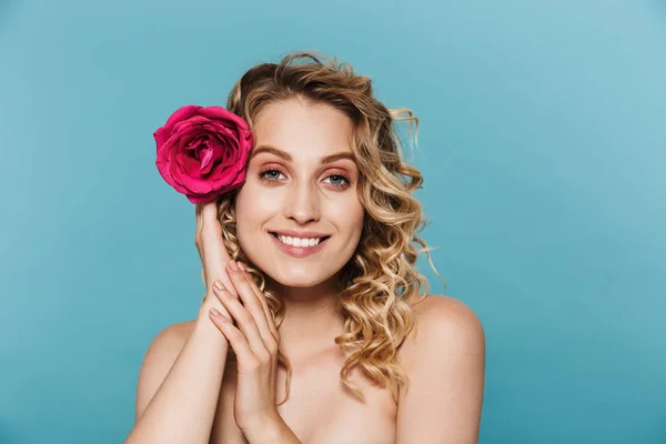 Bild närbild av unga halvnaken kvinna med rosa blomma i håret leende på kameran — Stockfoto