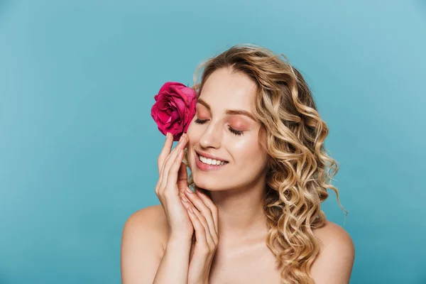 Imagen de primer plano de una encantadora mujer semidesnuda con flor rosa en el pelo sonriendo a la cámara cerrando los ojos —  Fotos de Stock