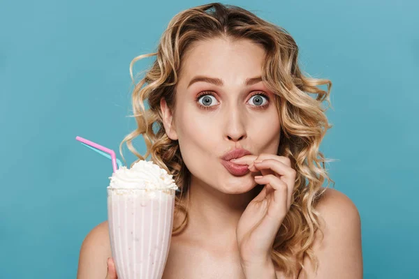 Изображение возбужденной полуголой женщины с вьющимися волосами, смотрящей в камеру, держа молочный коктейль — стоковое фото